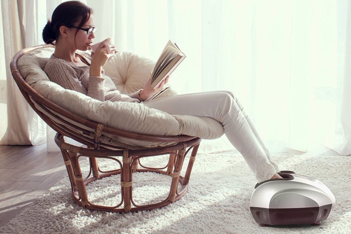 Woman reclining with her feet inside a Belmint foot massager.